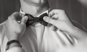 Shutterstock.com Les mains ajustent un nœud papillon sur le col